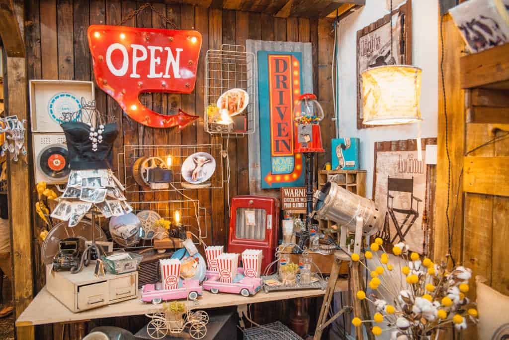 A room with a variety of items on display, including vases, books, and artwork.