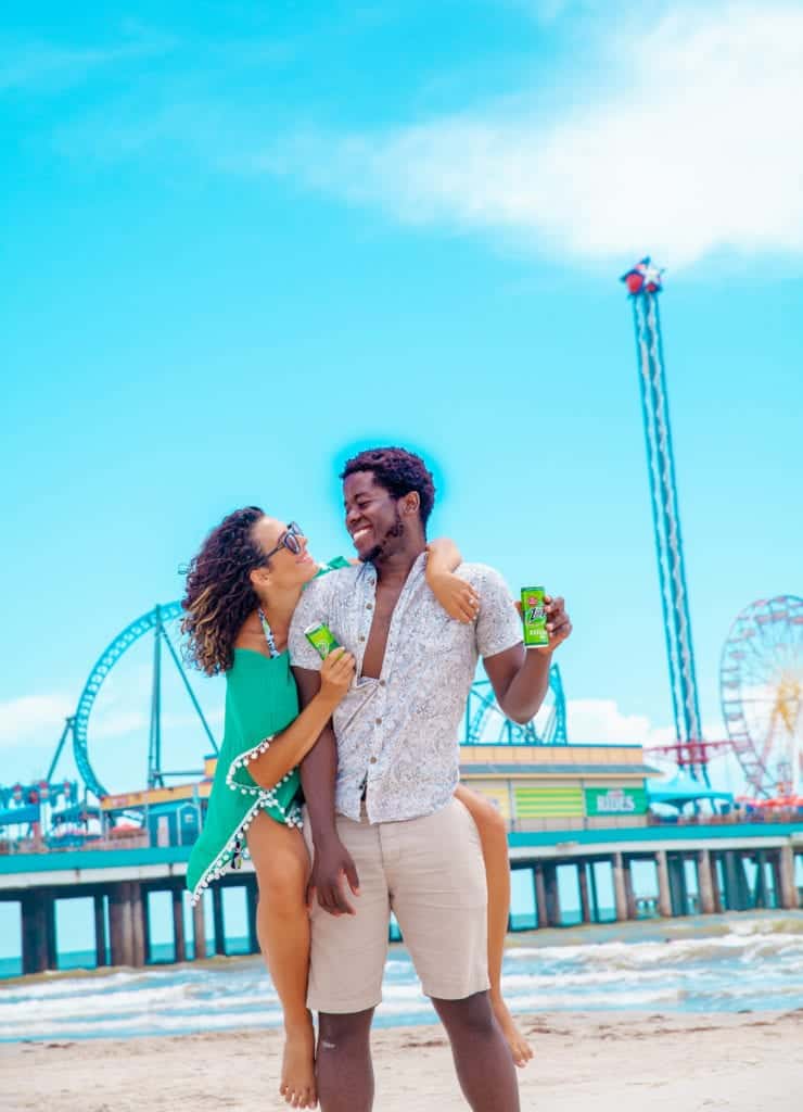 a man and woman holding each other on a beach