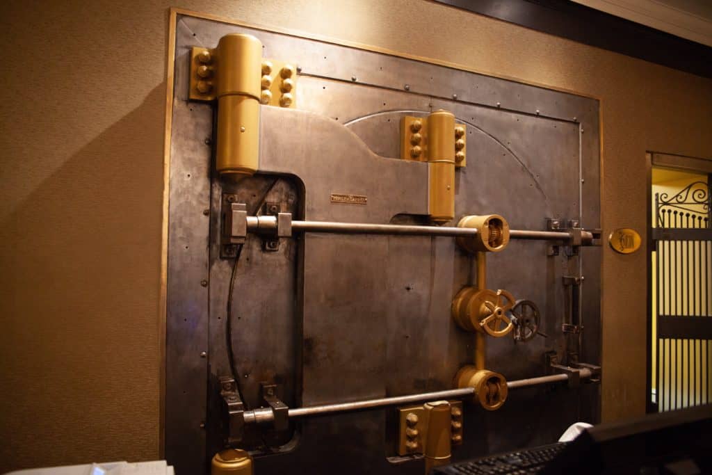 Large vintage metal bank vault door with secure locking mechanism.