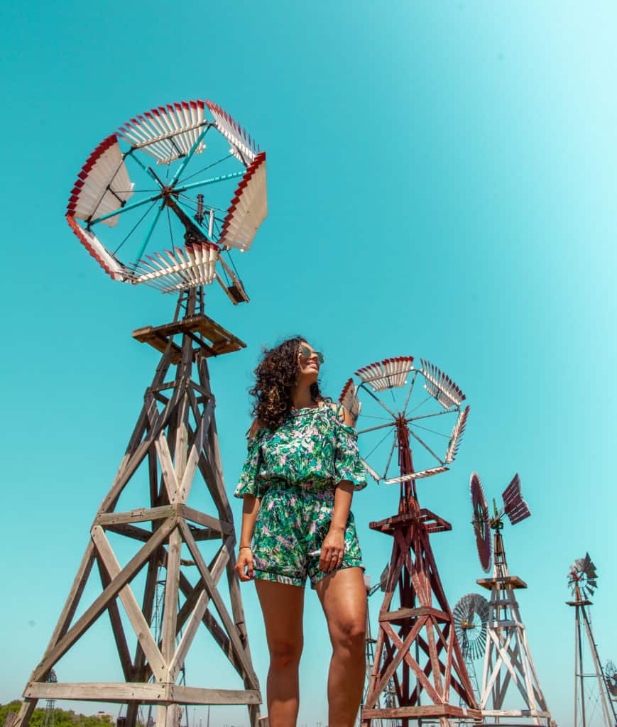 a person standing in front of windmills
