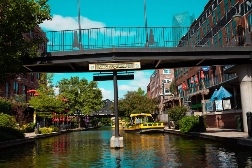 a yellow boat on a river under sandridge bridge