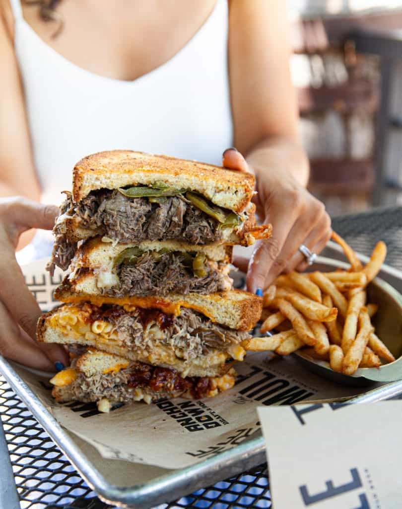 a person holding a stack of sandwiches