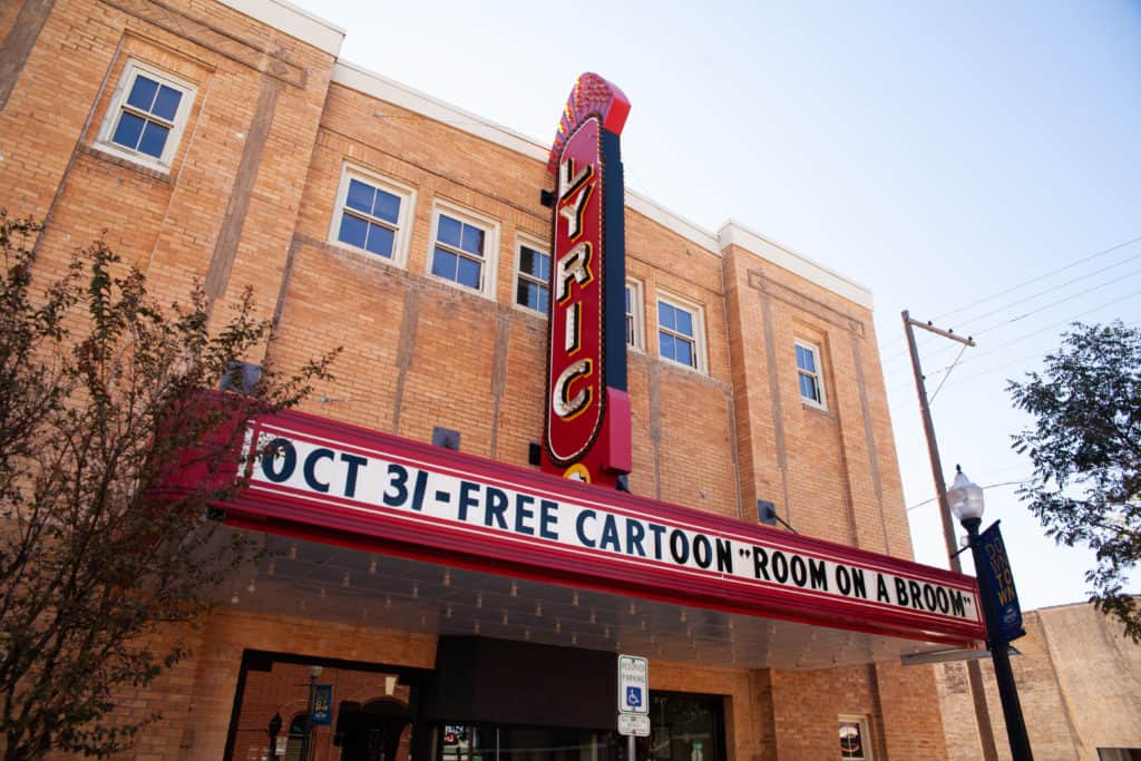 Vintage theater marquee with "Lyric" sign during the day.