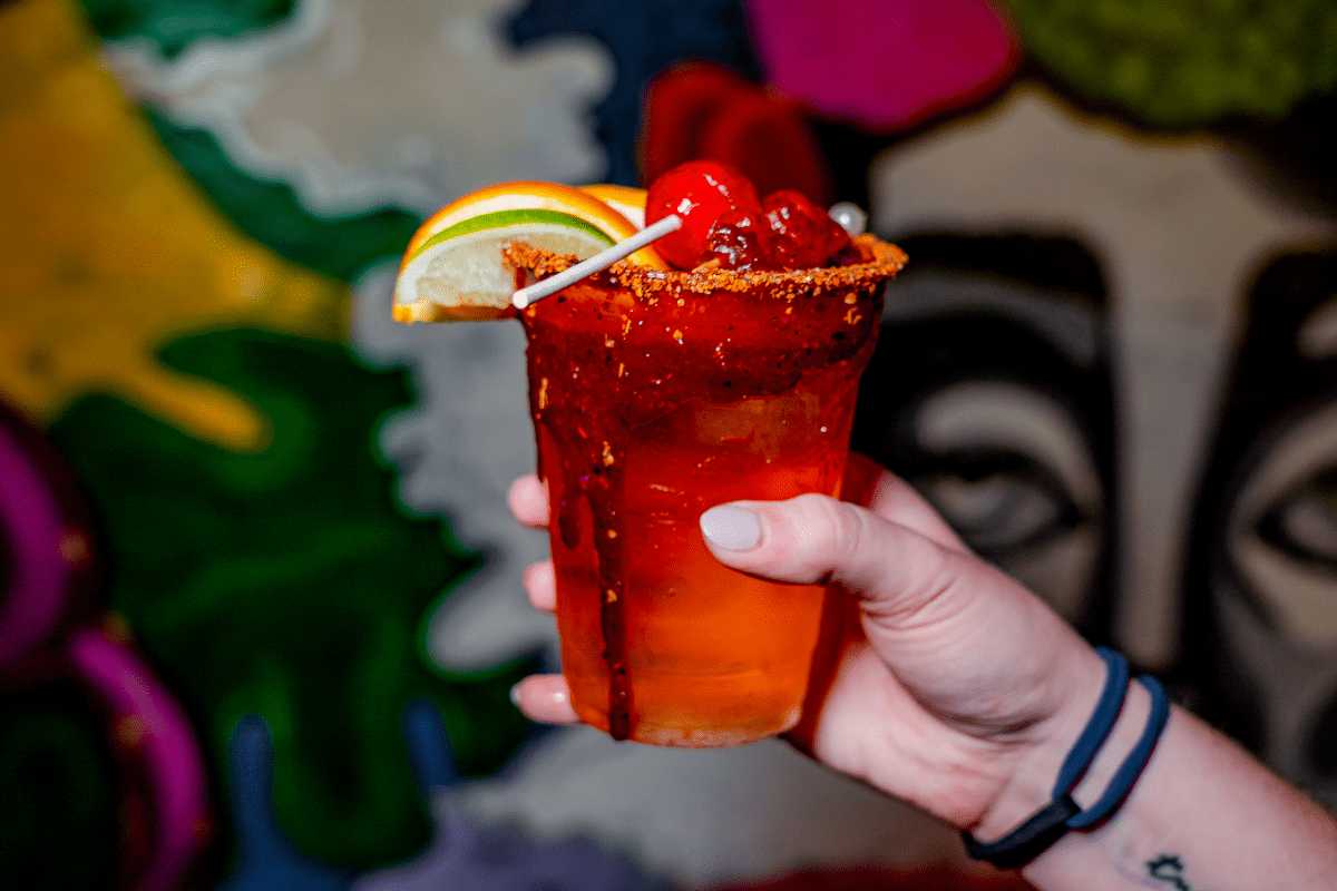 Beer with Chamoy and Tajin rim, candy, and fruit slices.