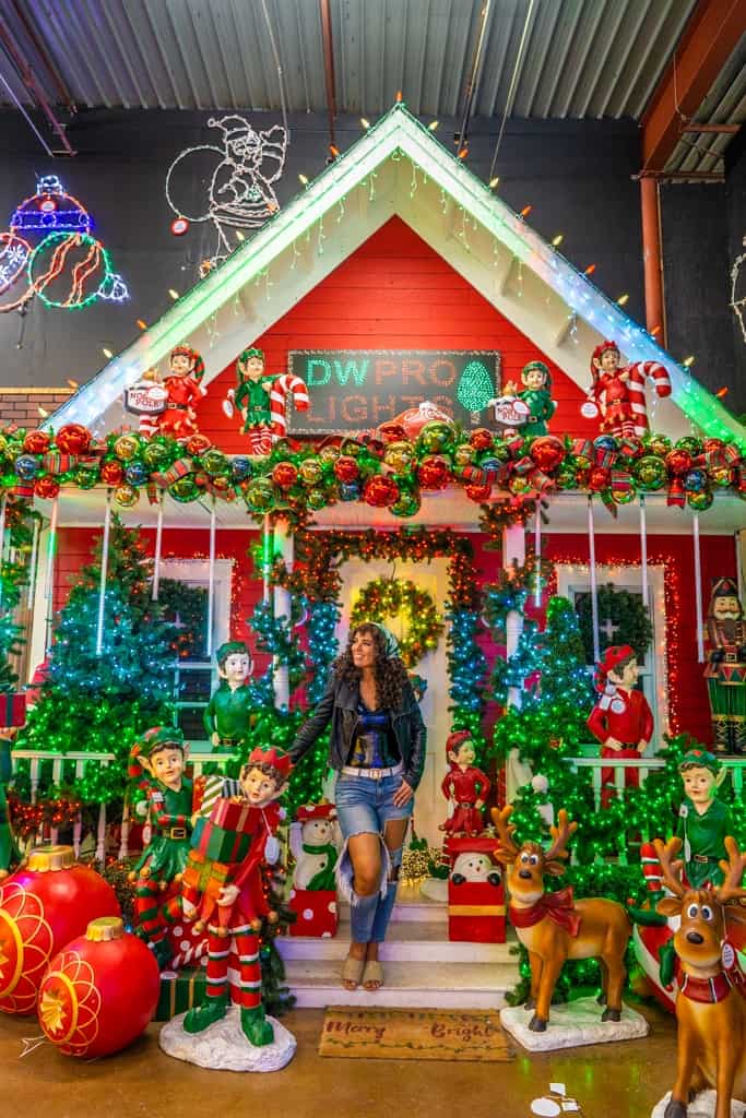 a person standing in front of a house decorated for christmas
