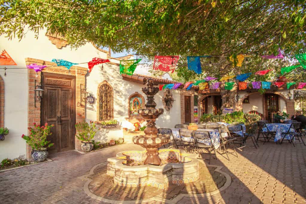 A vibrant courtyard of a Mexican restaurant adorned with colorful flags