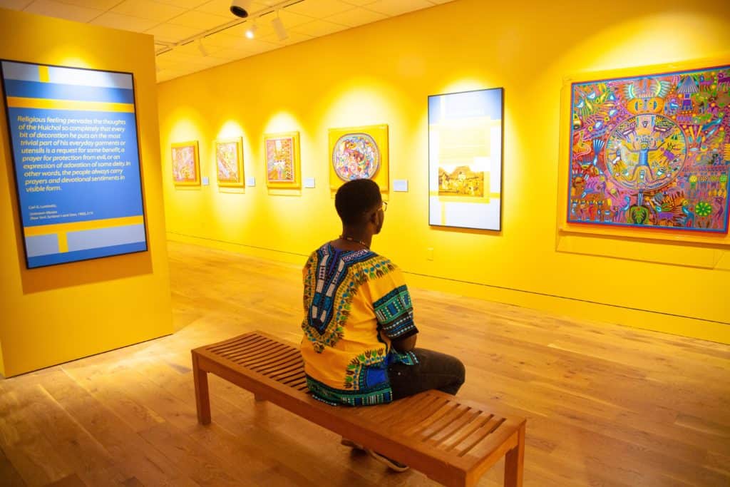 a person sitting on a bench in a museum