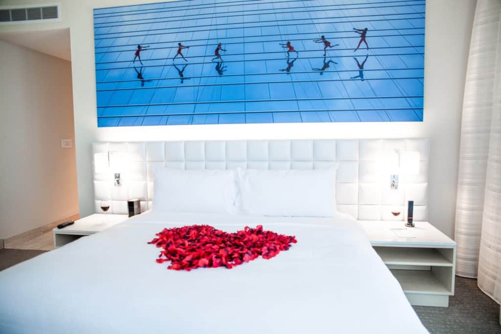cozy hotel room with a bed decorated with fresh roses on the sheets at Hall Arts Hotel Dallas