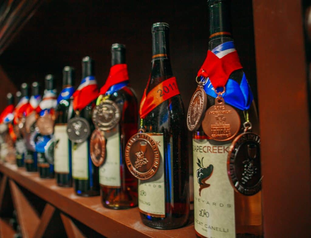 a row of wine bottles with medals