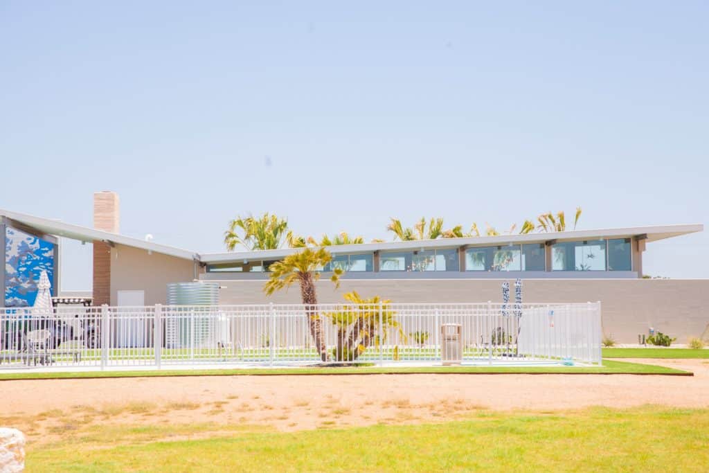 a building with a fence and palm trees