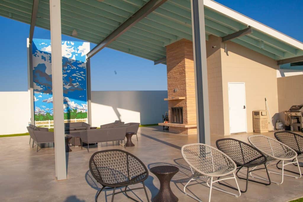 a patio with chairs and a fireplace