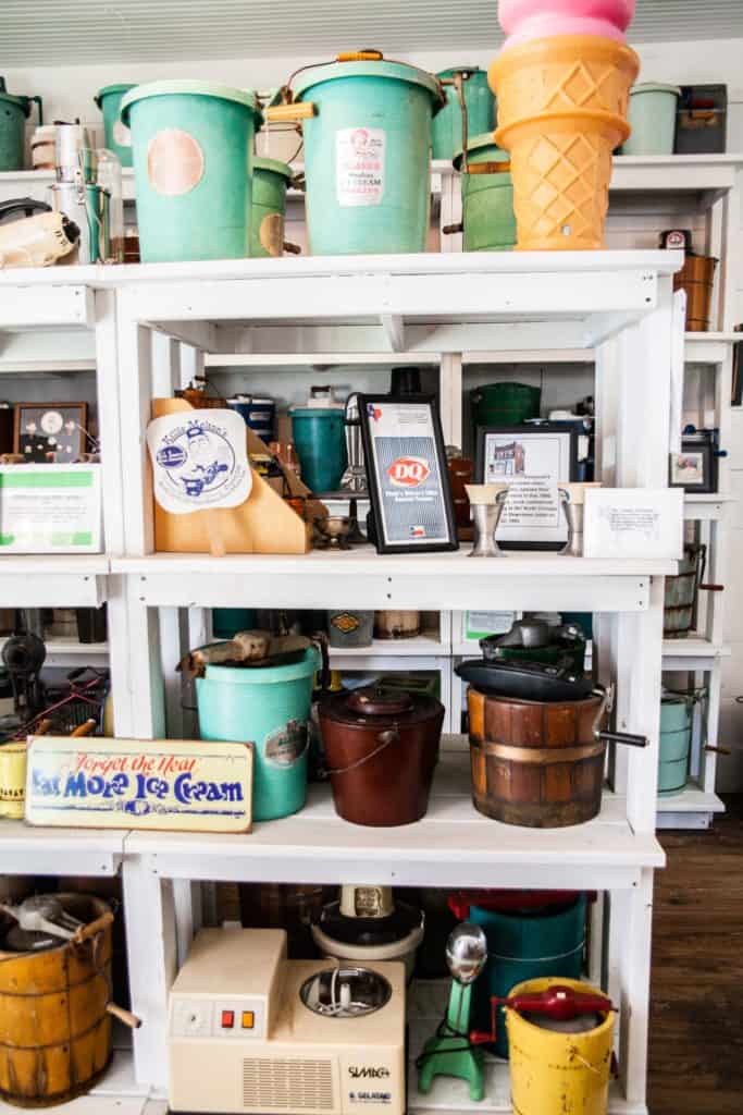 a shelf with different colored buckets