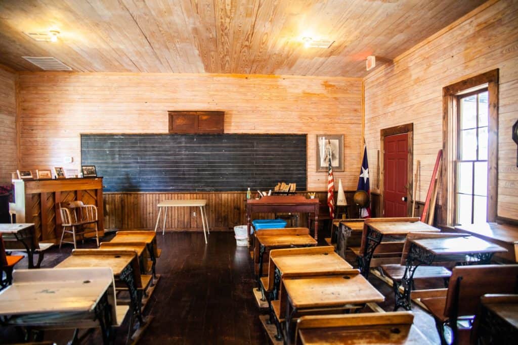 a room with wooden desks and a blackboard