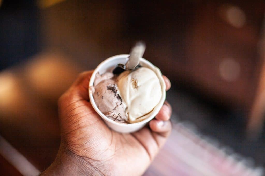 a hand holding a cup of ice cream