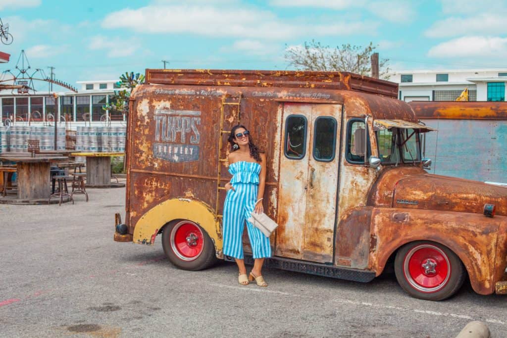 a person standing next to an old rusty truck