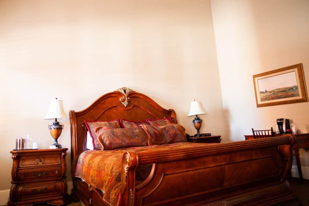 a bed with a wood headboard and lamp