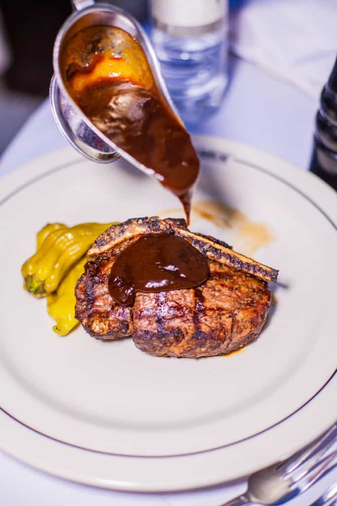 A juicy steak on a plate, drizzled with rich sauce