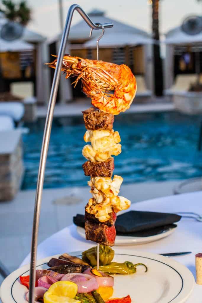 A plate featuring skewers of grilled meat at San Luis Resort