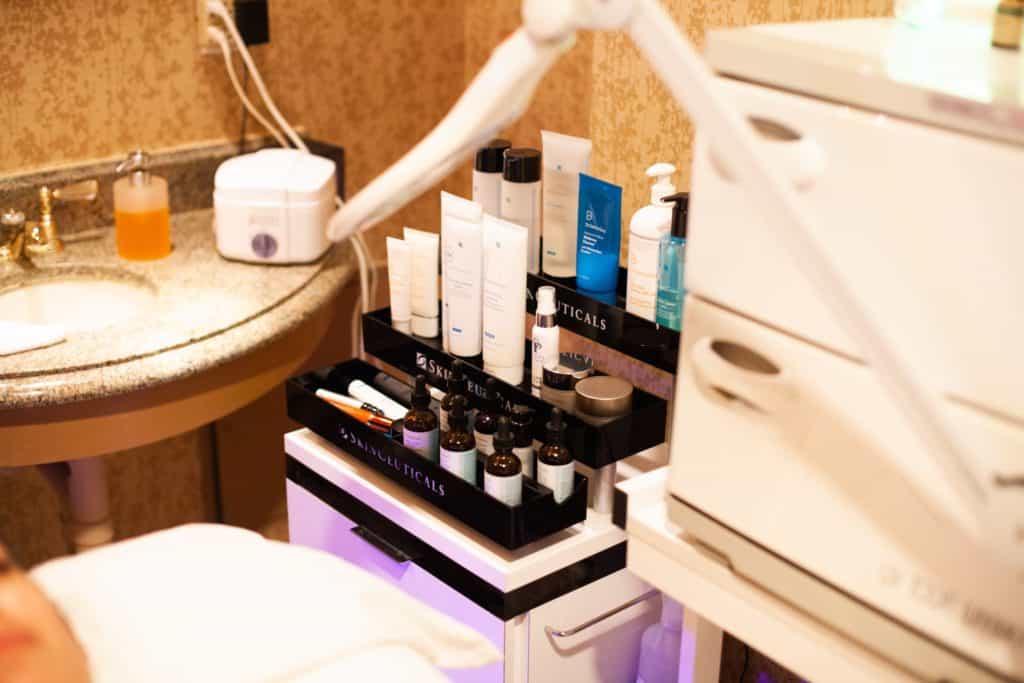 Skincare products arranged on a trolley beside a sink