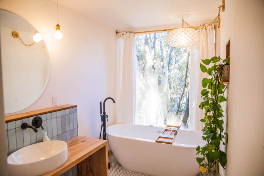 a bathroom with a tub sink and a window