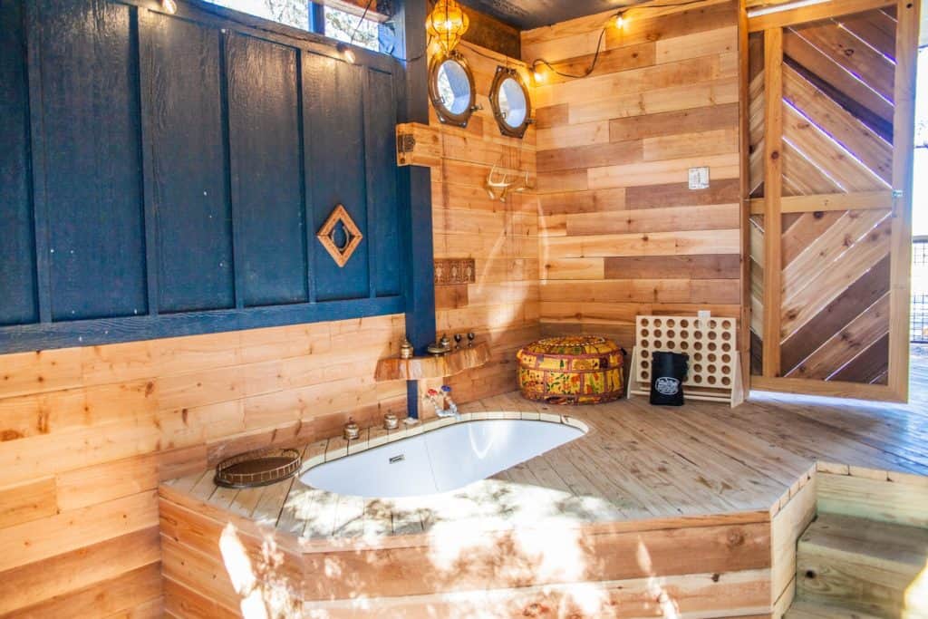 a bathroom with a tub and a wood wall