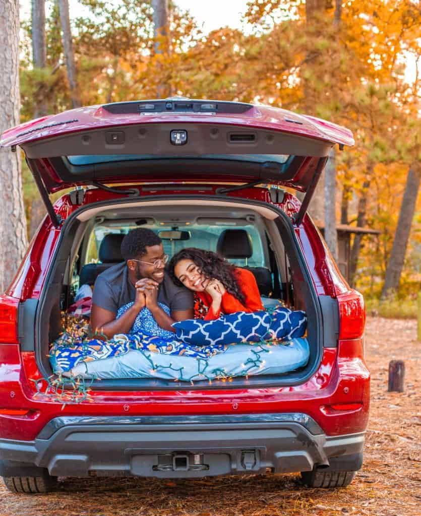 a person and person lying in the back of a car