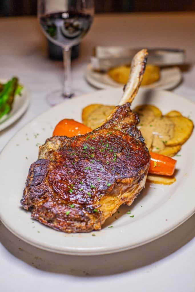 a piece of meat with vegetables on a white plate