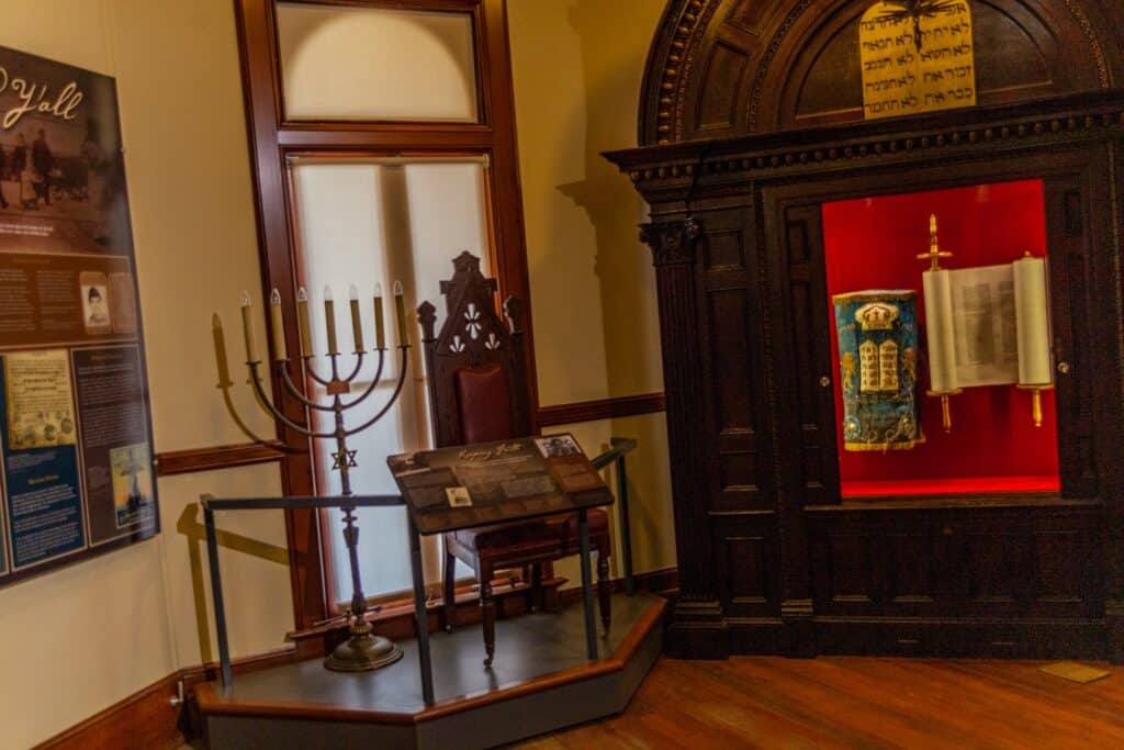 a room with a tall candle holder and a display case