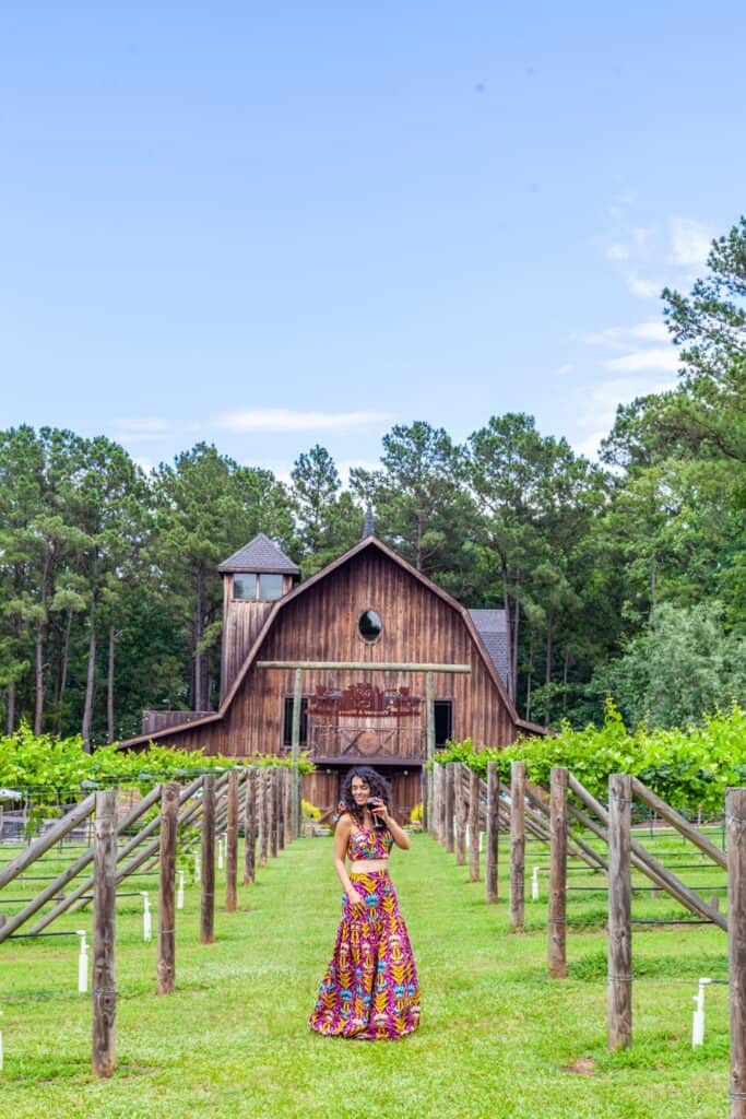 a person taking a selfie in front of a barn