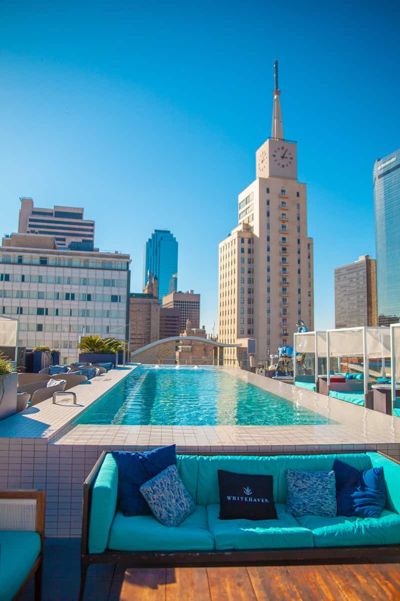 A hotel pool with a building in the background.
