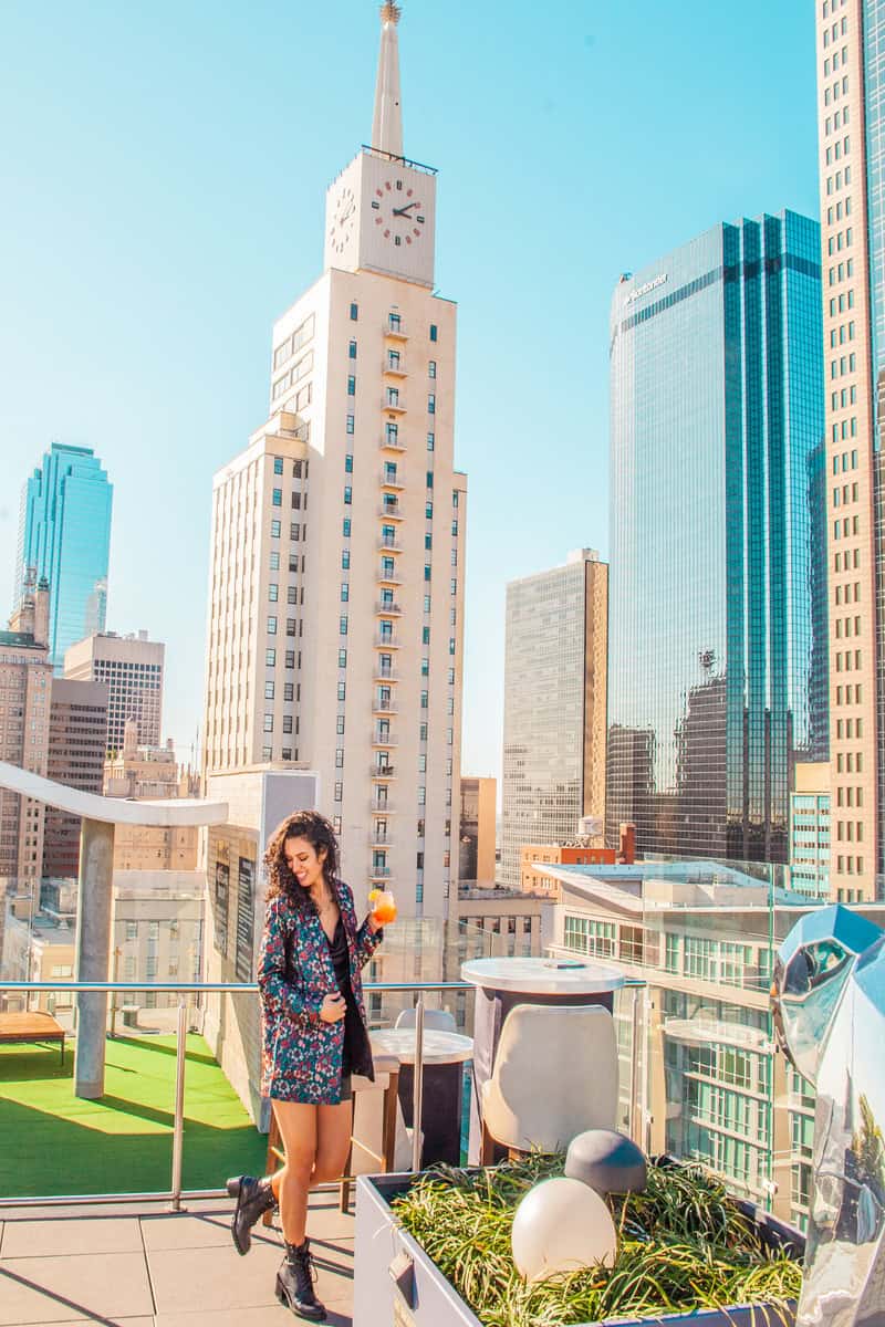 A woman on a rooftop, gazing at the city skyline.