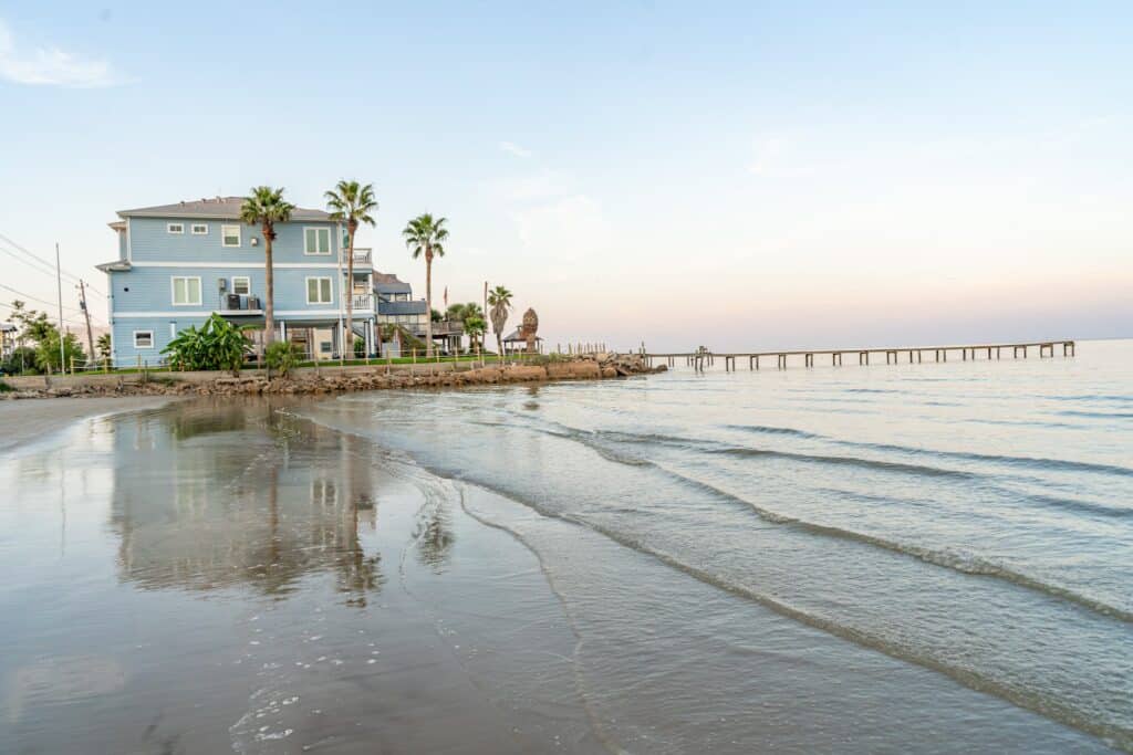 a beach with a house and palm trees