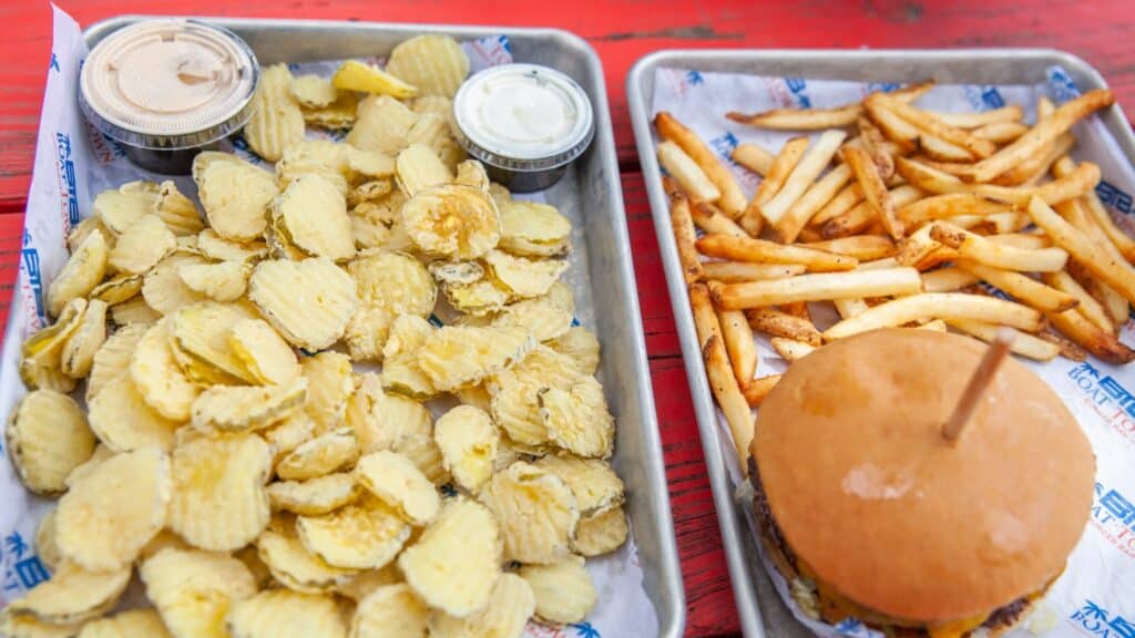 a trays of potato chips and a burger