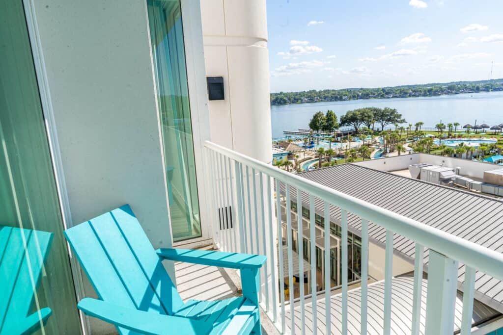 a blue chair on a balcony overlooking a body of water