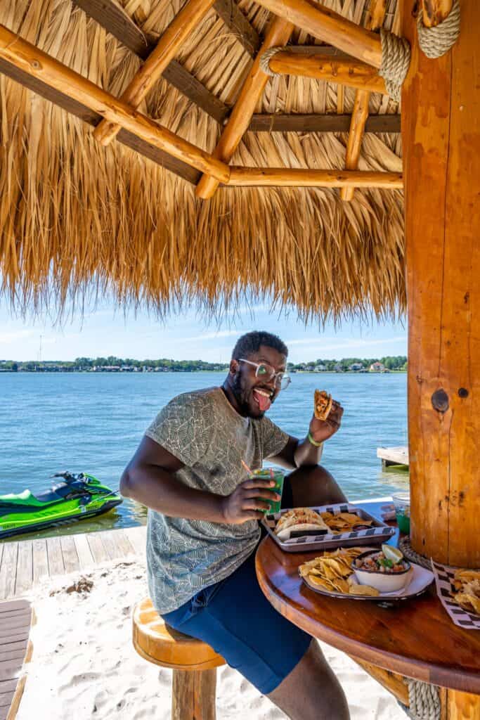 a person sitting at a table with food and drinks