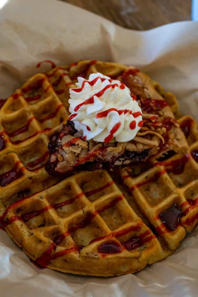 a waffle with whipped cream and syrup