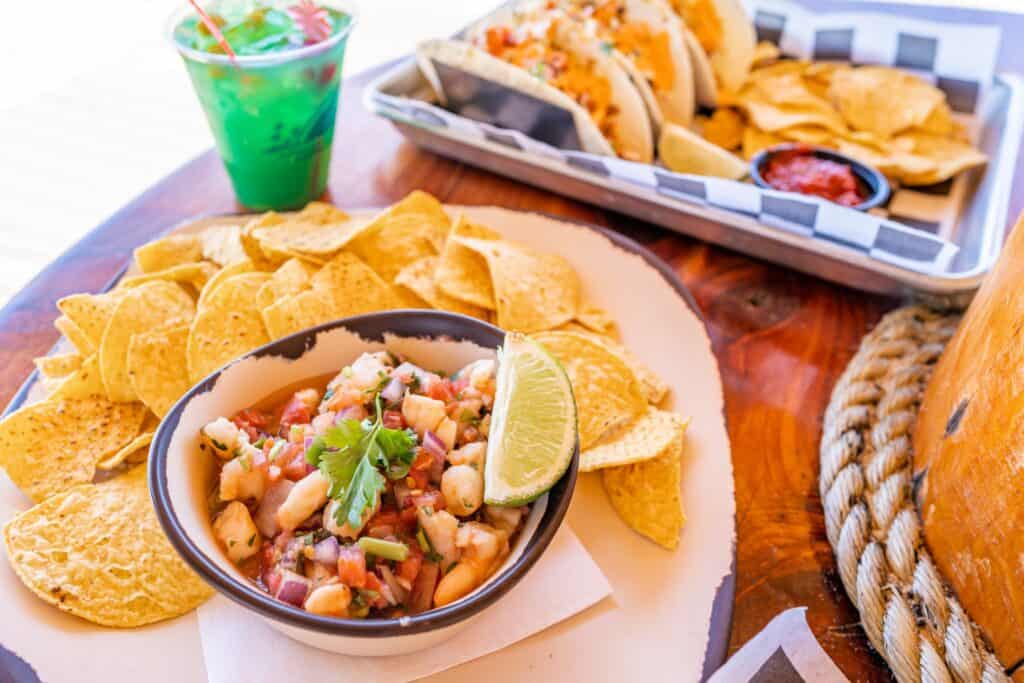 a bowl of food next to a plate of chips