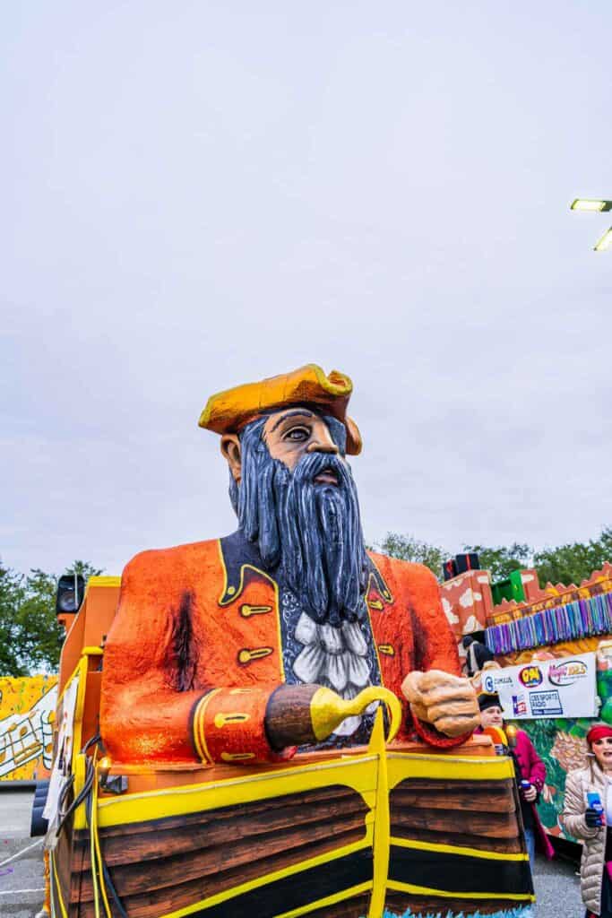 a statue of a pirate with a yellow hat and a yellow basket