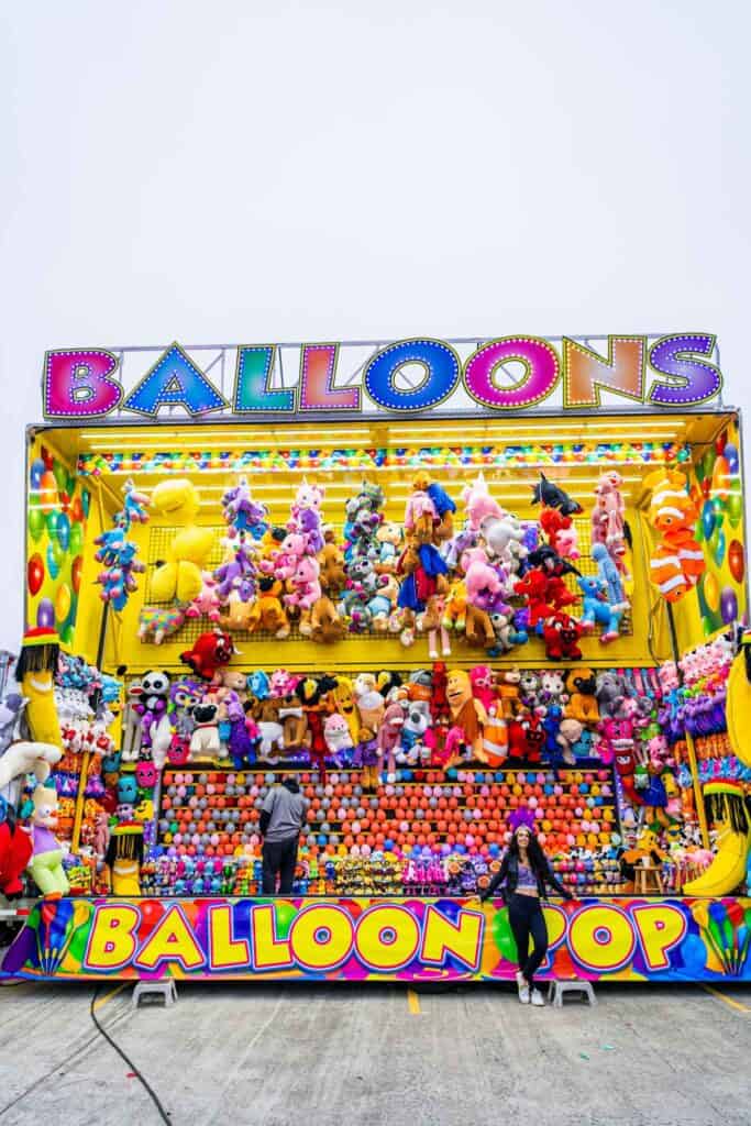 a group of people standing in front of a carnival game