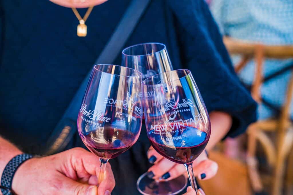 Three wine glasses filled with red wine clink together