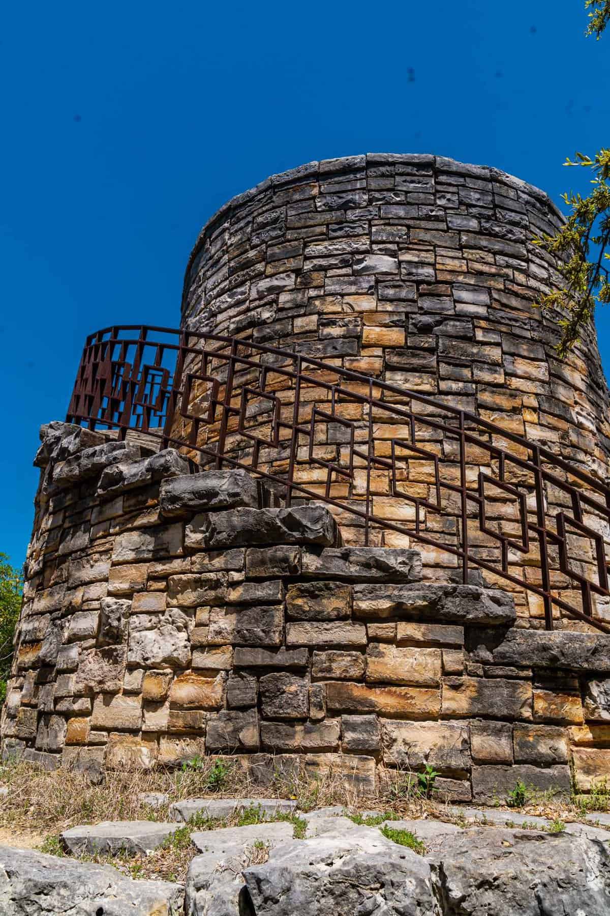 a stone tower with a metal railing