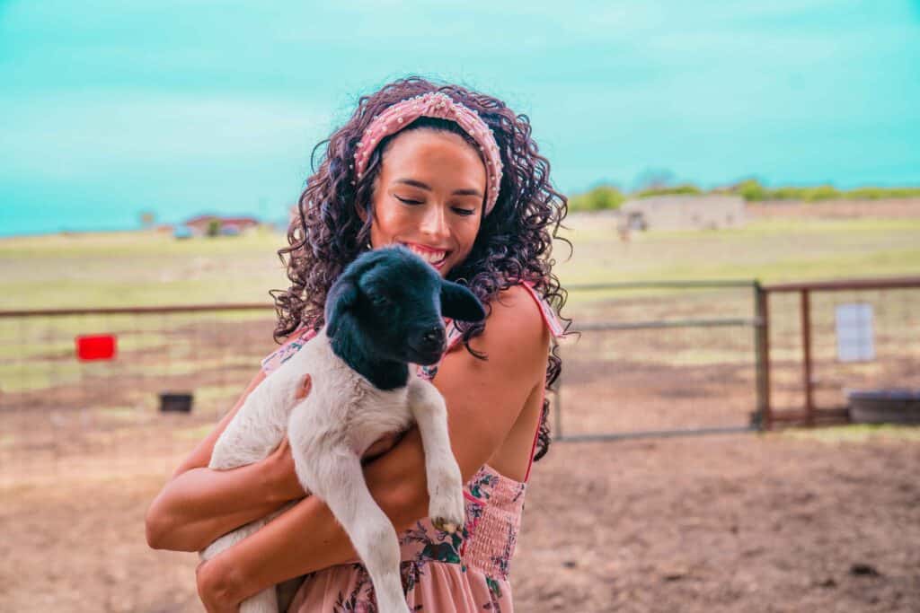 Jessica holding a baby lamb at Laughing Llama Farm in Belton Things to do