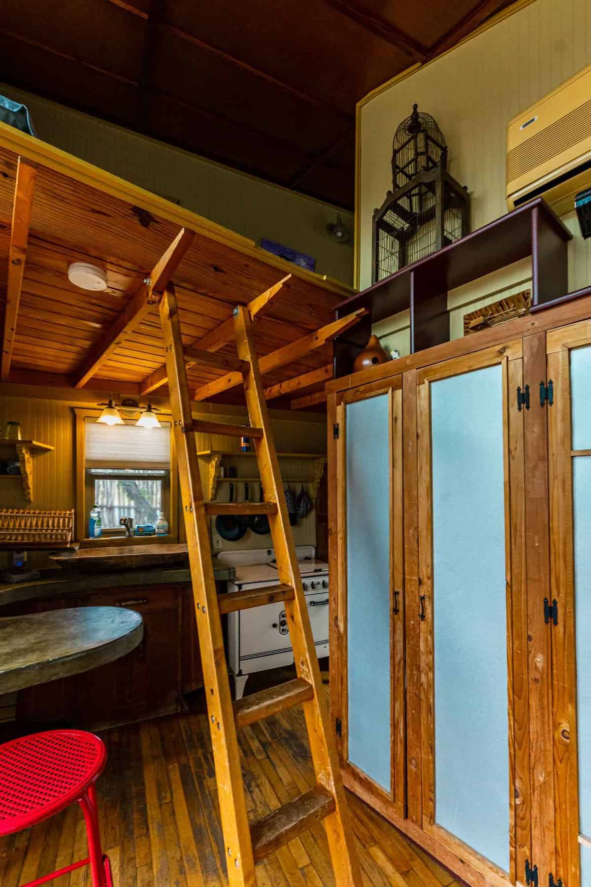 Lofted bed with ladder and kitchen inside funky blue eco-cabin