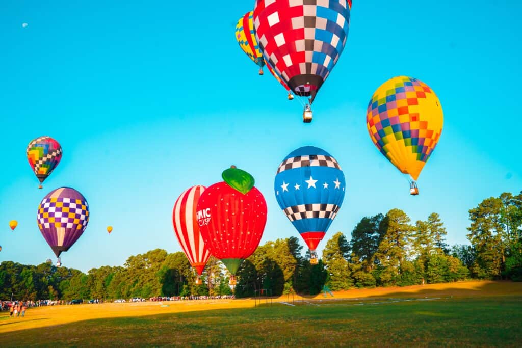 Colorful hot air balloons float gracefully in a clear blue sky