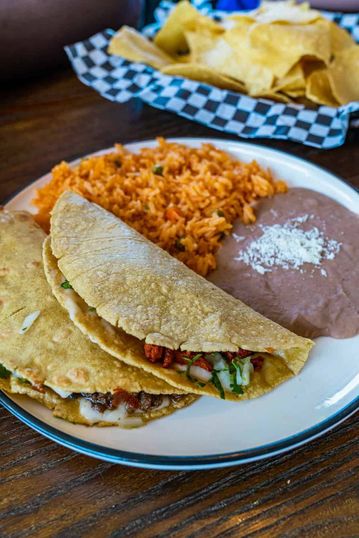 2 tacos with choice of meat (beef, chicken, or shrimp), with melted Oaxaca cheese. Served with rice and refried beans.