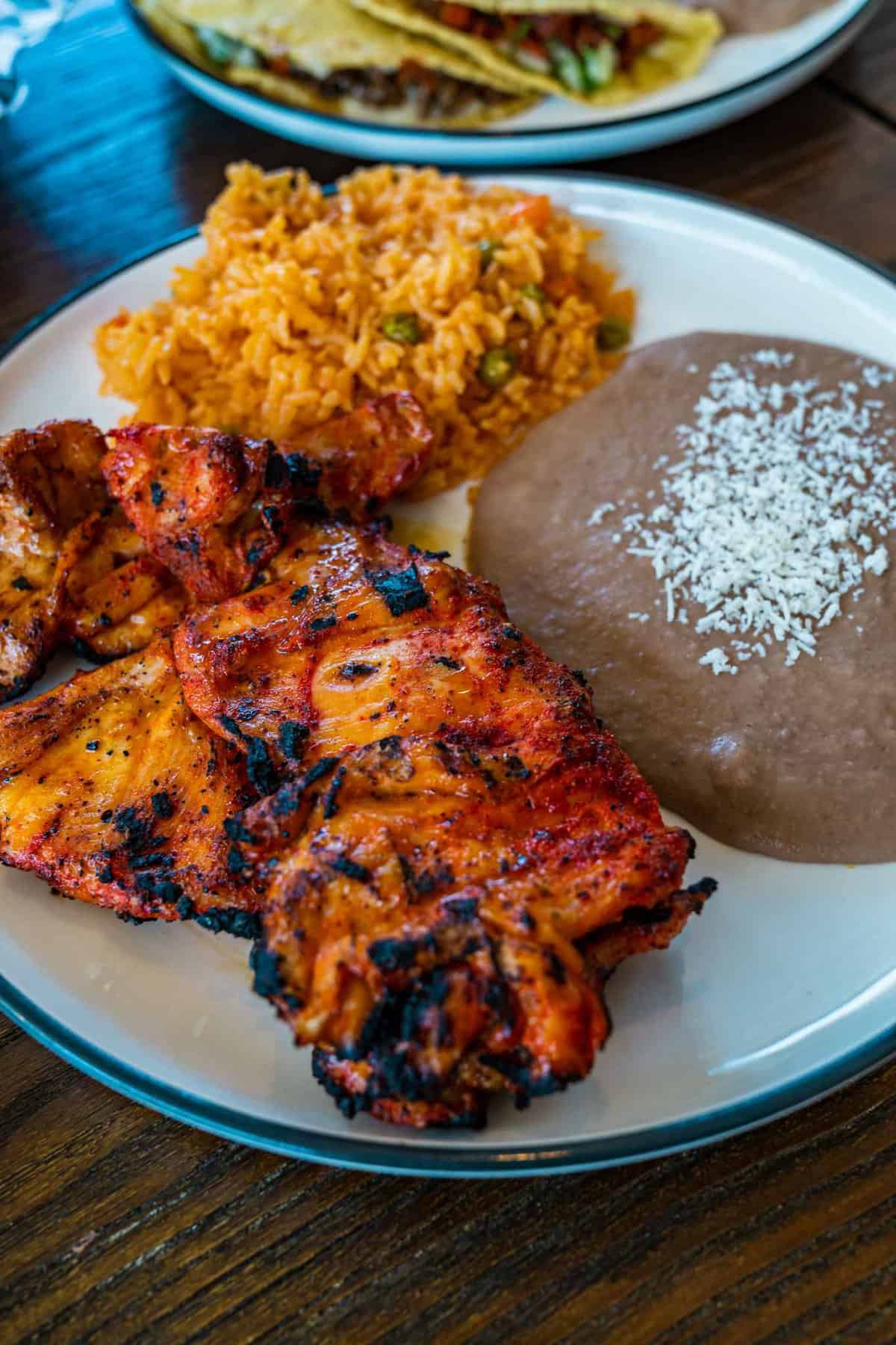 Grilled chicken seasoned with our signature spice blend. Served with rice, refried beans and 2 homemade corn tortillas.