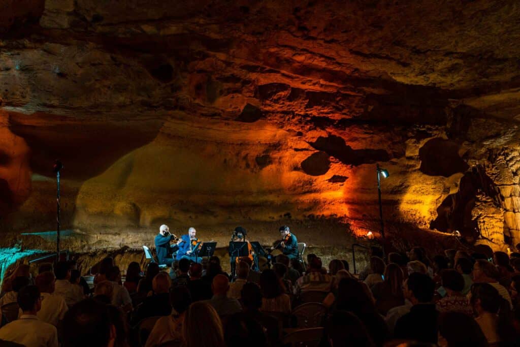 String quartet having a concert in a cave with audience