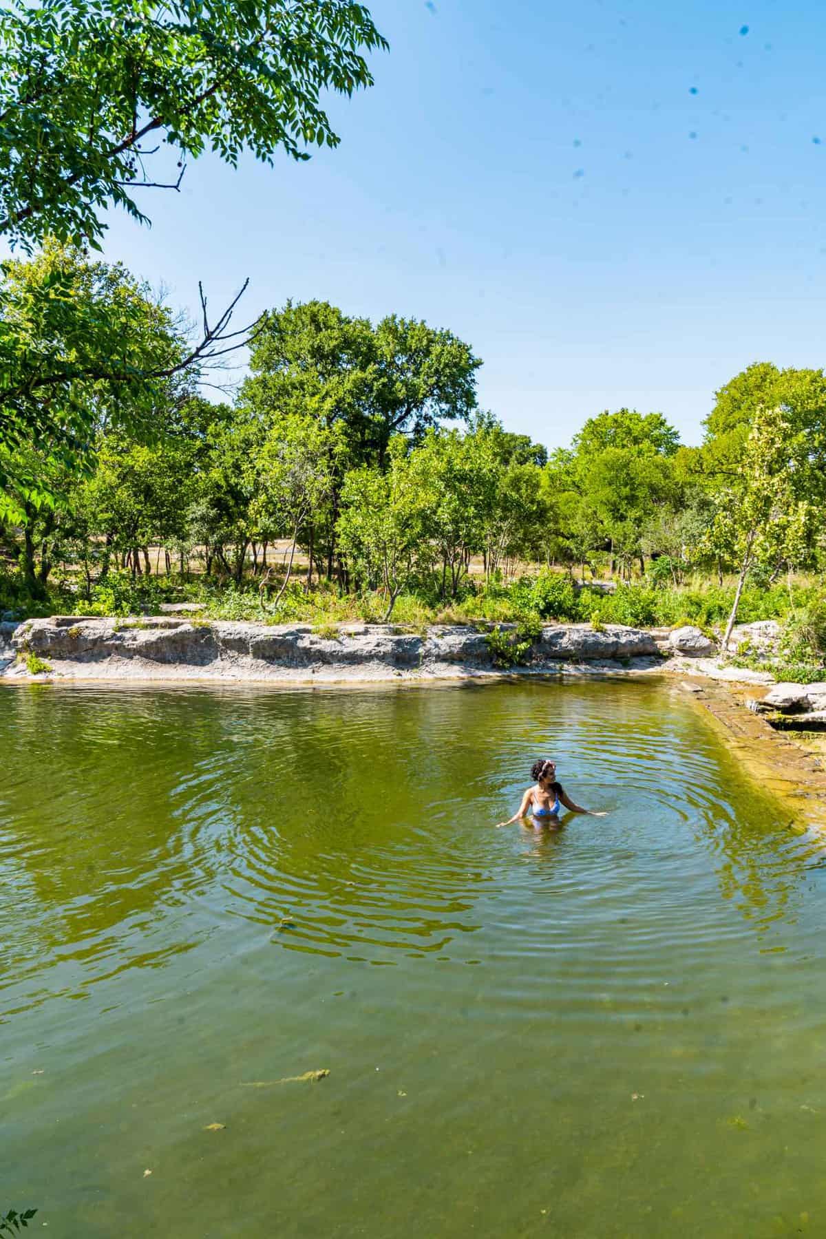 Lady swimming in a natural pool