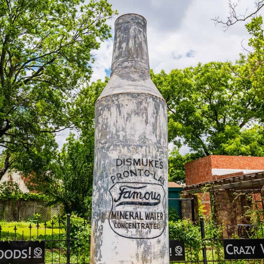 Statue of a bottle outside of the Crazy Water factory
