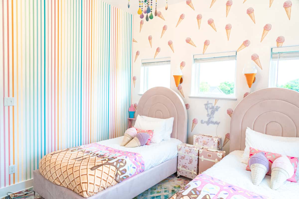 bedroom with twin beds and rainbow decal stickers on wall